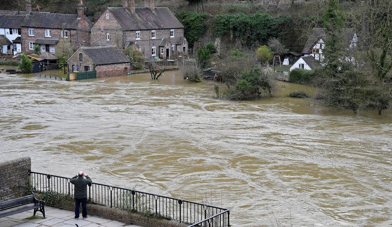 FILE PHOTO: A man views flooded properties beside the River Severn in Ironbridge, Britain,