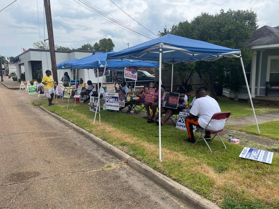 With a light rain coming down at noon, campaigners took shelter under tents as people came to vote in Tuesday's primary election at the J. T. Biggs, Jr. Memorial Library in Crystal Springs.