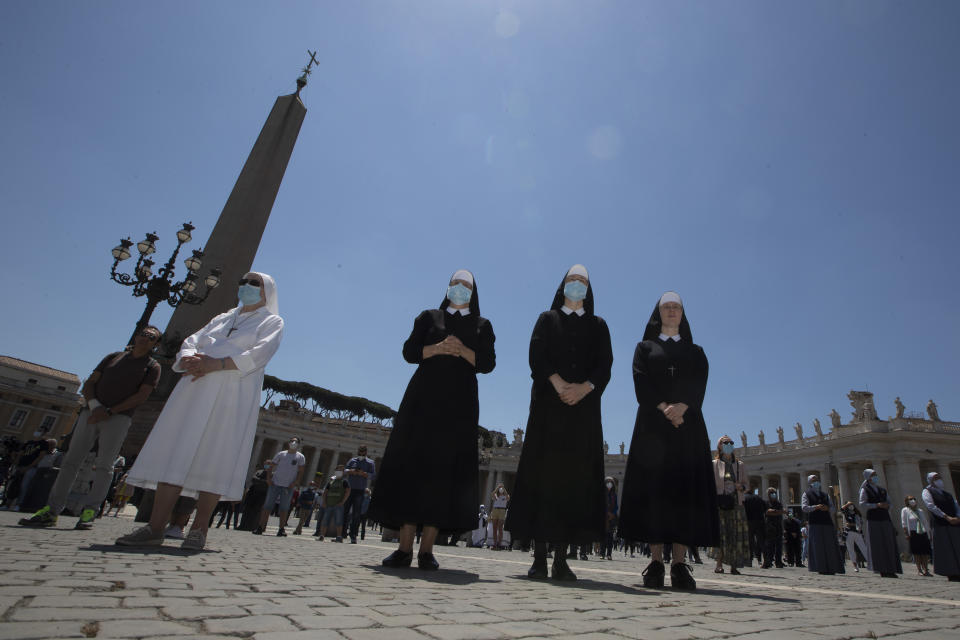 Nuns and faithful gather in St. Peter's Square at the Vatican, Sunday, May 31, 2020. Pope Francis has cheerfully greeted people in St. Peter’s Square on Sunday, as he resumed his practice of speaking to the faithful there for the first time since lockdown began in Italy and at the Vatican in early March. Instead of the tens of thousands of people who might have turned out on a similarly brilliantly sunny day like this Sunday, in pre-pandemic times, perhaps a few hundred came to the square, standing well apart from others or in small family groups. (AP Photo/Alessandra Tarantino)