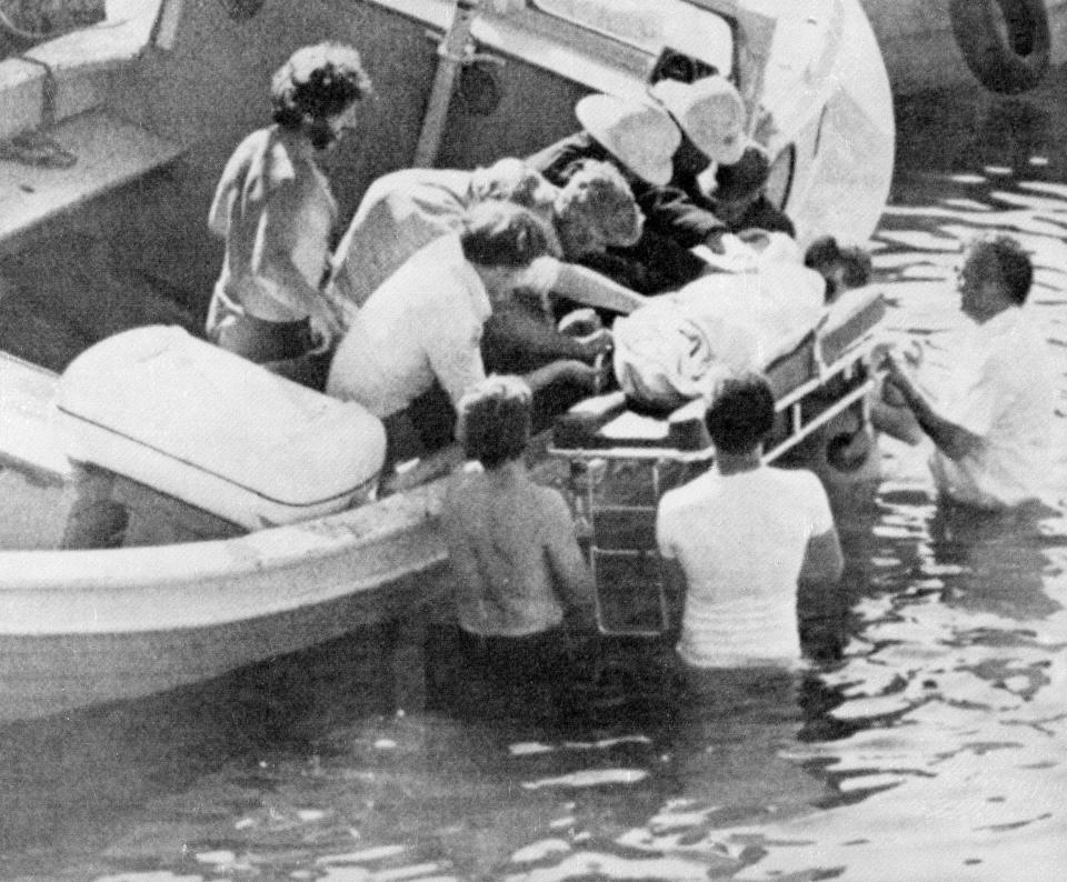 FILE - In this Aug. 27, 1979 file photo, workers lift an unidentified body from a small boat in Mullaghmore harbor after an explosion aboard a fishing boat killed Earl Mountbatten and two other people in Ireland. Mountbatten was setting out on a fishing trip with a family party when the boat exploded at Donegal Bay. The bomb was planted by the Irish Republican Army. Britain and Ireland joined the European Economic Community in 1973 and, that year, struck a peacemaking treaty on Northern Ireland. It created a Catholic-Protestant government pledged to cooperate with the Irish Republic. The coalition faced opposition both from most Protestants, who didn’t want to share power with the Irish minority, and the Provisional IRA, which wanted Northern Ireland overthrown, not reformed. Power-sharing collapsed in May 1974 as Protestant hard-liners brought Northern Ireland to a blacked-out standstill and detonated four no-warning car bombs in the Irish Republic, killing 33 civilians, the deadliest attack of the entire conflict. Years of military attrition followed, marked by the IRA’s 1979 killing of Lord Mountbatten, the queen’s cousin, and by a 1981 prison hunger strike that left 10 Irish republicans dead. (AP Photo, File)