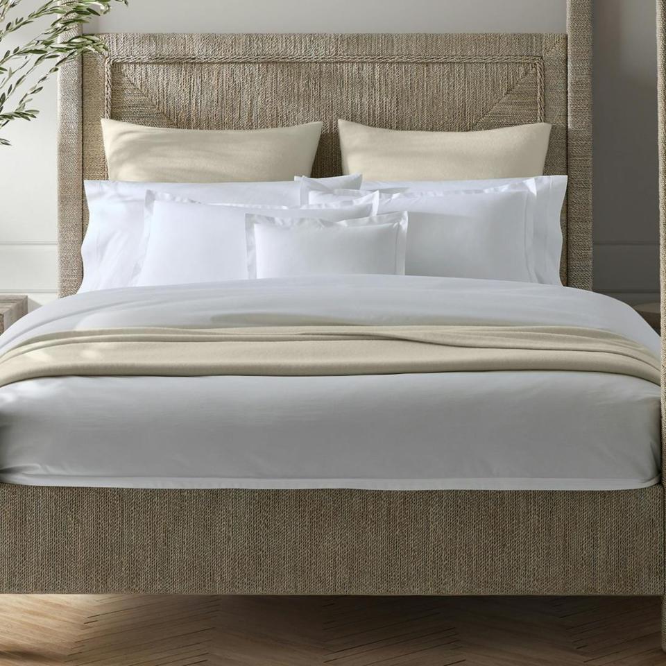 Matouk Luca Satin Stitch Linens on a bed.