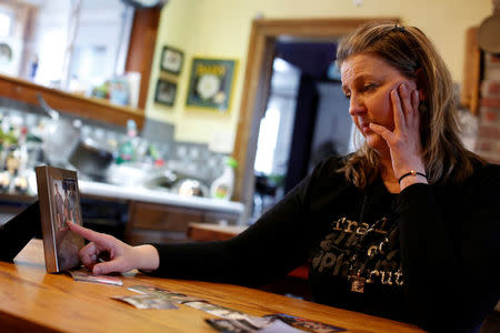 Alexis Pleus, Founder of Truth Pharm, looks at images of her son Jeff Dugon who died of an opioid overdose, during the taping of an interview with Reuters in Windsor, New York, U.S., April 6, 2018. REUTERS/Andrew Kelly