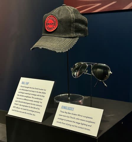 <p>Nancy Kruh</p> Eric Church's iconic aviators, along with a ball cap, on display at the Country Music Hall of Fame and Museum