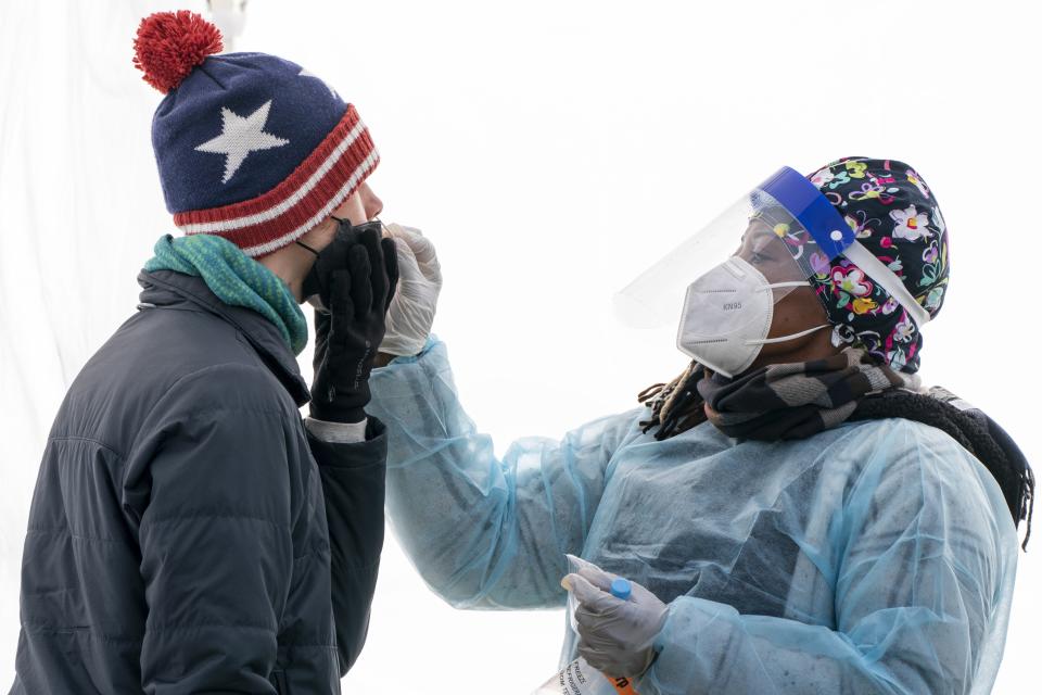 A man who said he wanted to be tested as a precaution ahead of the holidays, is swabbed for COVID-19 at a walk-up testing site at Farragut Square on Thursday, Dec. 23, 2021, just blocks from the White House in Washington. (AP Photo/Jacquelyn Martin)