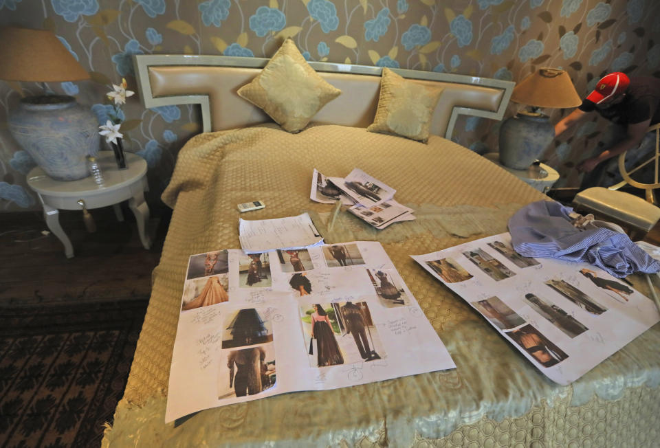 Photographs of models are spread on a bed during a shoot for the Lotus Make-up India Fashion Week, at the farmhouse of a designer in New Delhi, India, Friday, Oct. 2, 2020. Unlike a fashion show, models aren't swaying live on a ramp. They are depending on digital technology to rescue their annual extravaganza from the coronavirus pandemic with ''Phygital edition." India’s first digital fashion week is being held from Oct. 14-18, live streaming the spring-summer collections by more than 40 fashion designers. (AP Photo/Manish Swarup)