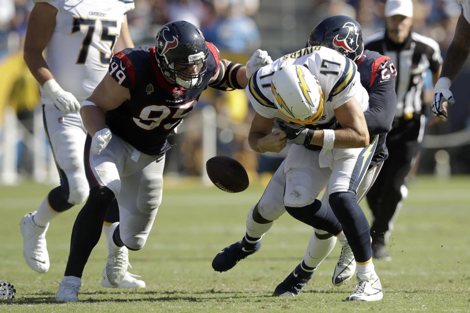 Houston Texans defensive end J.J. Watt, left, and outside linebacker Whitney Mercilus, right, force Los Angeles Chargers quarterback Philip Rivers to fumble during the second half of an NFL football game Sunday, Sept. 22, 2019, in Carson, Calif. (AP Photo/Marcio Jose Sanchez)