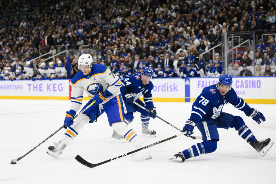 Buffalo Sabres right wing Tage Thompson (72) is defended by Toronto Maple Leafs defenseman TJ Brodie (78) and defenseman Morgan Rielly (44) during the first period of an NHL hockey game Saturday, Nov. 4, 2023, in Toronto. (Christopher Katsarov/The Canadian Press via AP)