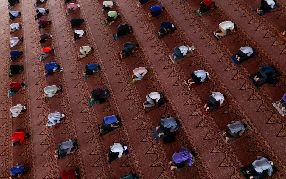 The faithful maintain social distance and wear protective face masks as they attend Friday prayer at a mosque in Putrajaya, outside Kuala Lumpur - FAZRY ISMAIL/EPA-EFE/Shutterstock 
