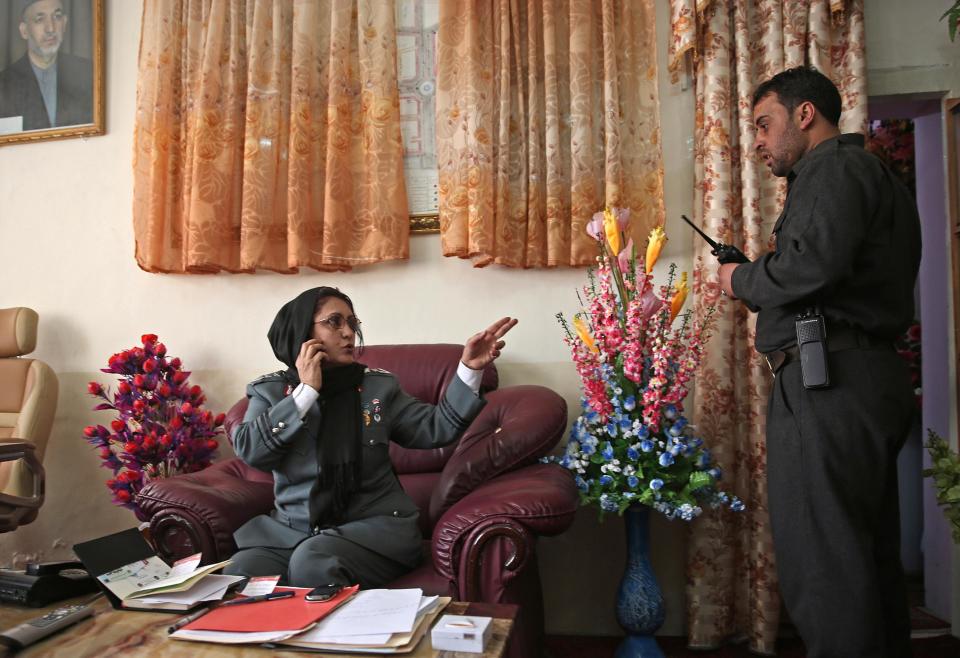 Afghanistan's first-ever female district police chief, Col. Jamila Bayaz, 50, left, talks to her secretary at her office in Kabul, Afghanistan, Thursday, Jan. 16, 2014. Afghanistan's first-ever female district police chief drew stares on Thursday as she drove and walked around the center of the city, reviewing check points and some of the important business and administrative facilities she is tasked with protecting. (AP Photo/Massoud Hossaini)