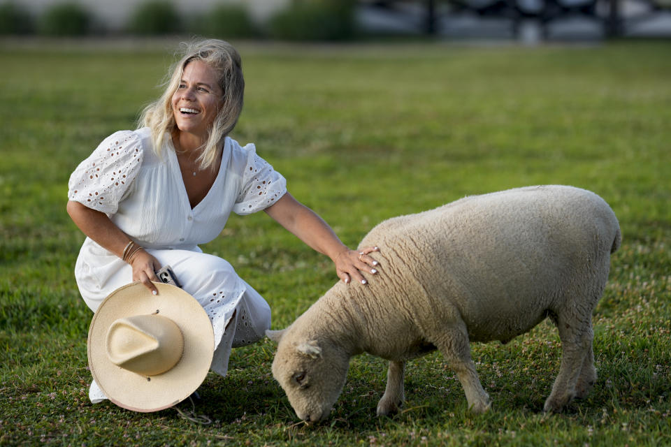 Jamie Campion pets her one of her Southdown Babydoll sheep as it grazes in the backyard Wednesday morning, July 3, 2024, in Thompson Station, Tenn. (AP Photo/George Walker IV)