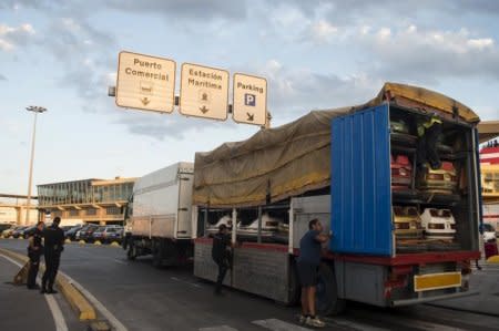 FILE PHOTO: Spanish police officers and fair workers search for migrants hiding in a fairground truck heading to board a ferry to continental Spain, in Spain's North African enclave of Melilla, September 8, 2015.  REUTERS/Jesus Blasco de Avellaneda