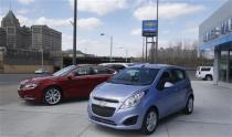 A General Motors 2014 Chevrolet Impala (L) and Spark car (R) are displayed in front of a Chevrolet dealership on Woodward Avenue in Detroit, Michigan April 1, 2014. REUTERS/Rebecca Cook