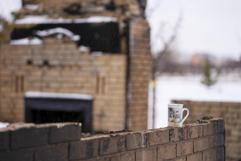 A winter-themed mug sits on the wall of a home destroyed by the Smokehouse Creek Fire, Thursday, Feb. 29, 2024, in Stinnett, Texas. (AP Photo/Julio Cortez)