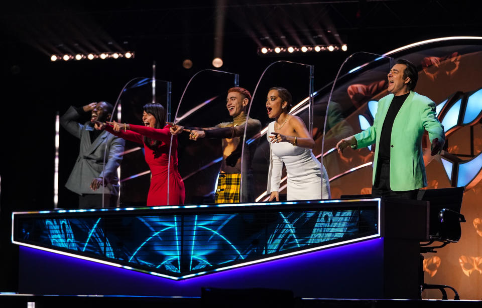 This image and the information contained in it are strictly embargoed until 00:01 Saturday 29 January 2022. From Bandicoot TV 'The Masked Singer': SR3: Ep6 on ITV and ITV Hub. Pictured: Mo Gilligan, Davina McCall, Olly Alexander, Rita Ora, Jonathan Ross. This photograph is (C) Bandicoot TV and may only be reproduced for editorial purposes directly related to the above programme or event or ITV plc. Once made available by ITV plc Picture Desk, this photograph may only be reproduced once up to the transmission (TX) date and no reproduction fee will be charged. Any subsequent use may incur a fee. This photograph must not be manipulated in any way (other than simple cropping) that alters the visual appearance of the person photographed and is deemed detrimental or inappropriate by ITV plc Picture Desk.  This photograph may not be syndicated to any other company, publication or website, or permanently archived without the express written permission of ITV Picture Desk. Full terms and conditions can be found on the website www.itv.com/presscentre/itvpictures/terms. For further information please contact: james.hilder@itv.com / 0207 157 3052