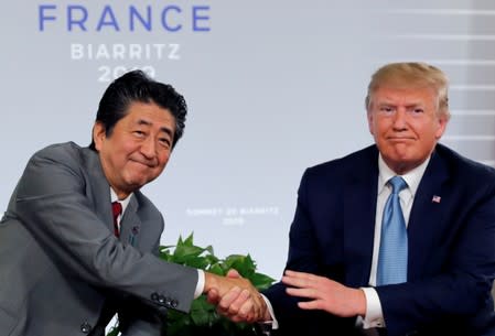 FILE PHOTO: U.S. President Trump and Japan's Prime Minister Abe shake hands at a bilateral meeting during the G7 summit in France