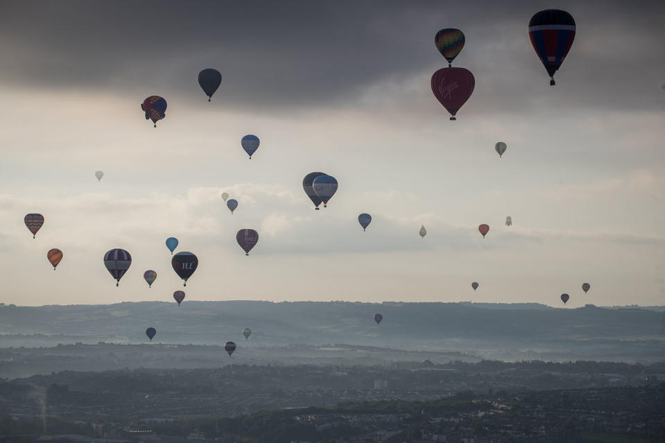 <p>Hot air balloons take to the skies as they participate in the mass assent at sunrise on the second day of the Bristol International Balloon Fiesta on August 11, 2017 in Bristol, England. (Photo: Matt Cardy/Getty Images) </p>