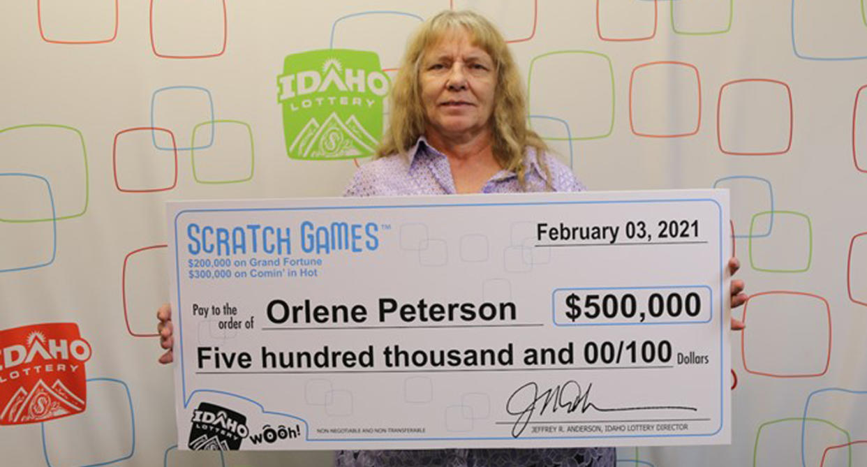 Orlene Peterson holding up a lottery cheque for $500,000 us dollars