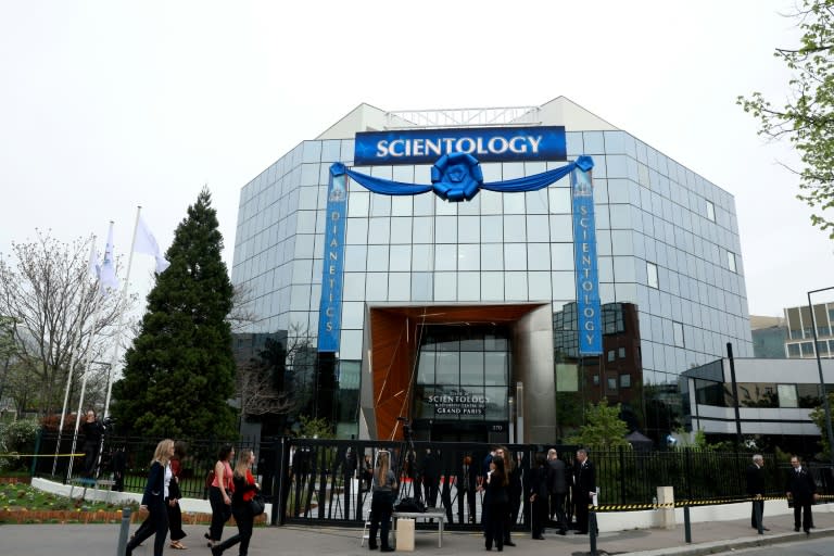 Des personnes invitées à l'inauguration du nouveau centre de formation de l'Eglise de scientologie arrivent devant le bâtiment le 6 avril 2024 à Saint-Denis, près de Paris (Emmanuel Dunand)