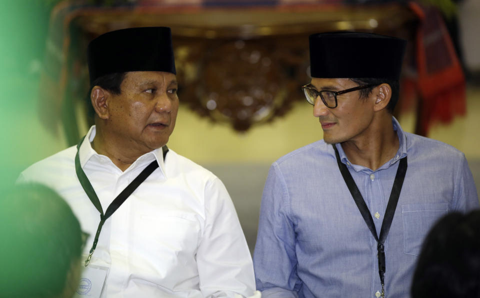 Indonesian presidential candidate Prabowo Subianto, left, talks to his running mate Sandiaga Uno during formal registration as candidates for the 2019 presidential election in Jakarta, Indonesia, Friday, Aug. 10, 2018. Prabowo is running with businessman and deputy Jakarta governor Sandiaga Salahuddin Uno. Both officially registered as candidates after Friday prayers. (AP Photo/Achmad Ibrahim)