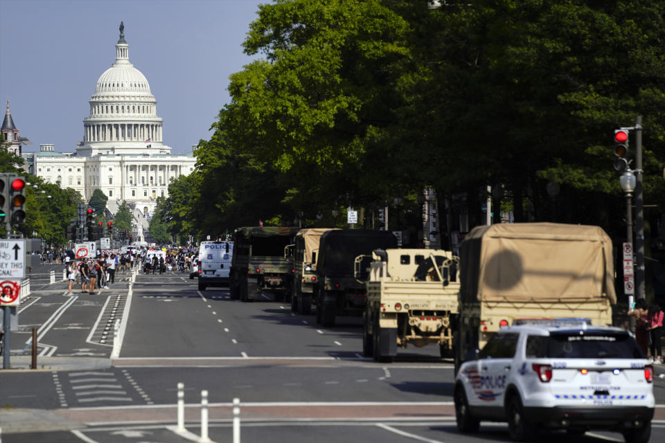 Demonstrators walk along Pennsylvania Avenue as a line of police and military vehicles drive as they protest the death of George Floyd, Wednesday, June 3, 2020, in Washington. Floyd died after being restrained by Minneapolis police officers. (AP Photo/Evan Vucci)