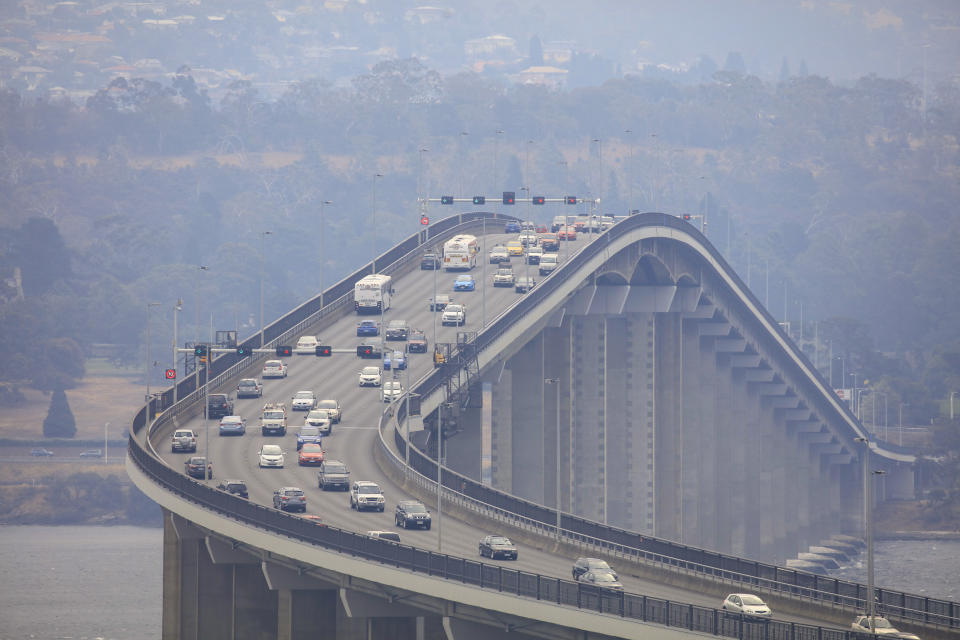 Smoke from multiple uncontrolled wildfires is seen at the Tasman Bridge in Hobart. Source: AAP