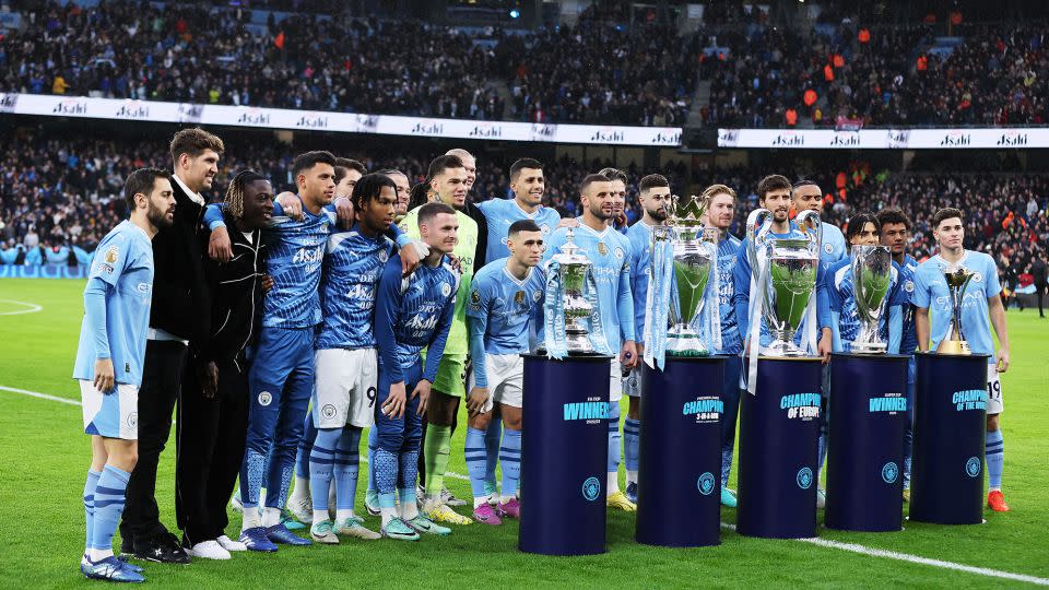 City's squad poses with its trophy haul from the 2023 calendar year at the Etihad. - Jan Kruger/Getty Images