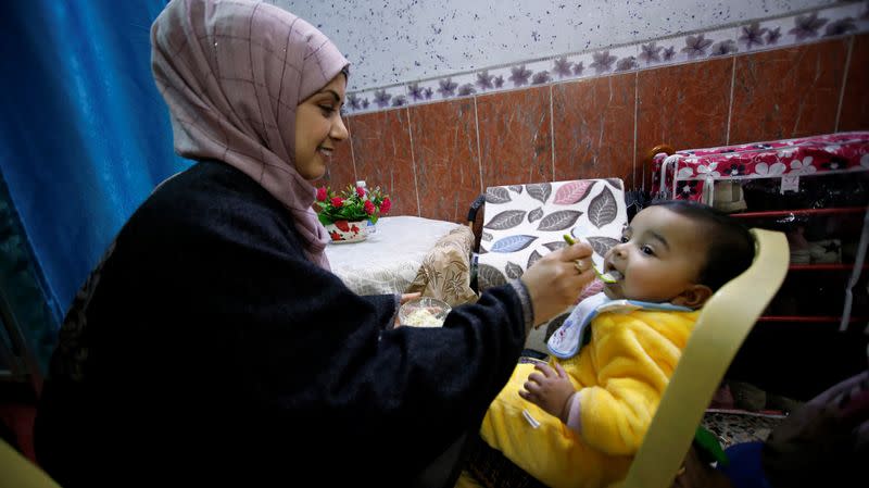 Jassem, 24, an Iraqi nurse feeds her nephew at home in Baghdad