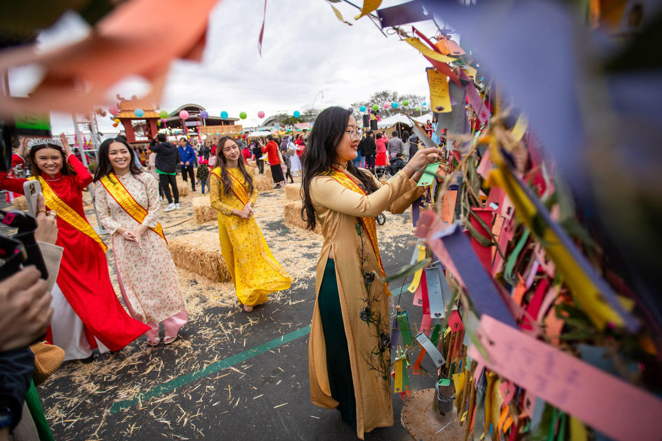 Michelle Ngo hangs her wish on the wishing tree at the 41st Union of The Vietnamese Student Association Tet Festival at the Orange County Fair & Events Center in Costa Mesa, Calif., last year. (Allen J. Schaben / Los Angeles Times via Getty Images file)