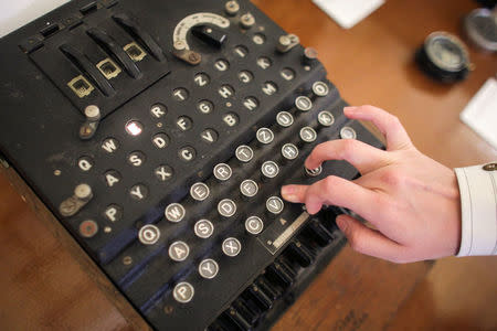 An employee of an auction house presses a key on an working original Enigma cipher machine that is on display at an auction house in Bucharest, Romania, July 11, 2017. Inquam Photos/Octav Ganea/via REUTERS