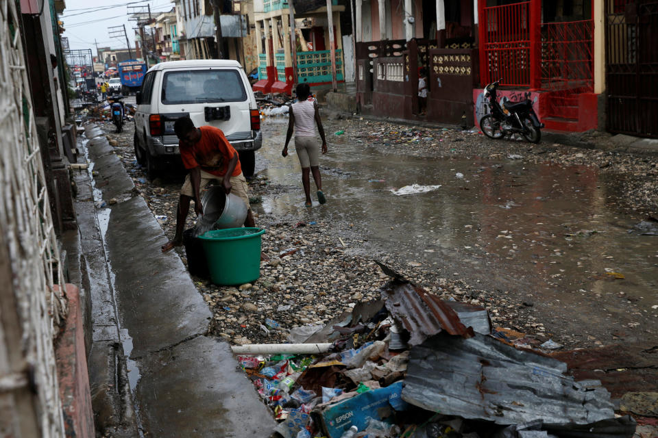 A man collects rain water in a plastic container on the street&nbsp;on&nbsp;Oct. 16, 2016.