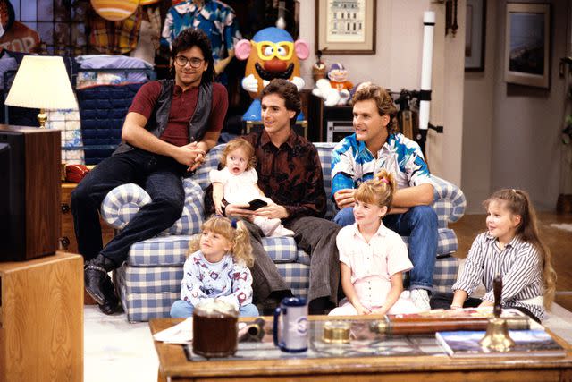 <p>ABC Photo Archives/Disney General Entertainment Content via Getty</p> Jesse (John Stamos), Stephanie (Jodie Sweetin), Michelle (played by twins Mary Kate/Ashley Olsen), Danny (Bob Saget), Joey (Dave Coulier), Kimmy (Andrea Barber) and D.J. (Candace Cameron)