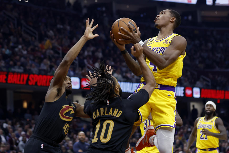 Los Angeles Lakers guard Lonnie Walker IV (4) shoots against Cleveland Cavaliers guard Darius Garland (10) and guard Donovan Mitchell (45) during the first half of an NBA basketball game Tuesday, Dec. 6, 2022, in Cleveland. (AP Photo/Ron Schwane)