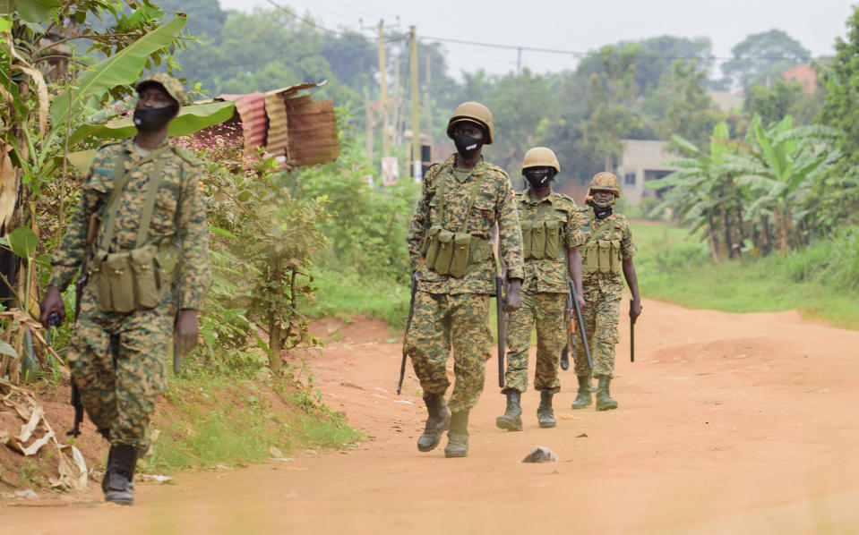 Soldiers patrol outside opposition challenger Bobi Wine's home in Magere, Kampala, Uganda, Saturday, Jan. 16, 2021, after President Yoweri Museveni was declared the winner of the presidential election. Uganda’s electoral commission says longtime President Yoweri Museveni has won a sixth term, while top opposition challenger Bobi Wine alleges rigging and officials struggle to explain how polling results were compiled amid an internet blackout. In a generational clash widely watched across the African continent, the young singer-turned-lawmaker Wine posed arguably the greatest challenge yet to Museveni. (AP Photo/Nicholas Bamulanzeki)