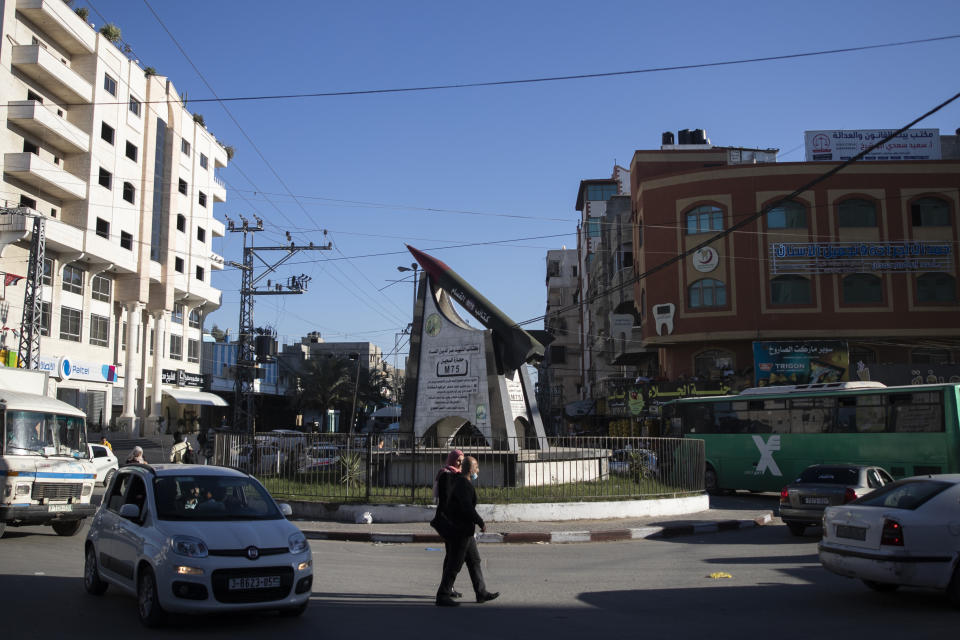 Palestinians walk monument to a Qassam rocket Gaza City, Wednesday, Dec. 15, 2021. Gaza’s Hamas rulers collect millions of dollars a month in taxes and customs at a crossing on the Egyptian border – providing a valuable source of income that helps it sustain a government and powerful armed wing. After surviving four wars and a nearly 15-year blockade, Hamas has become more resilient and Israel has been forced to accept that its sworn enemy is here to stay. (AP Photo/ Khalil Hamra)