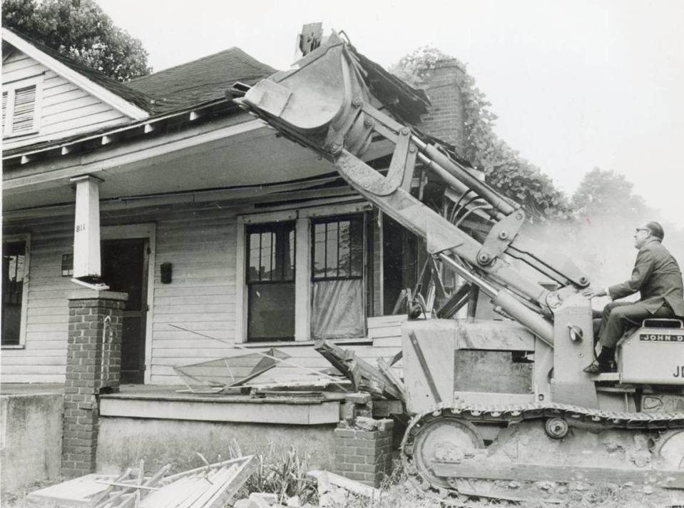 February 1970: A bulldozer pushes over the first house in Brooklyn, an old Charlotte neighborhood, to make way for “urban renewal.”