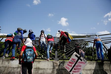 Demonstrators climb and brake down a fence that delimits an Air force base while rallying against Venezuela's President Nicolas Maduro's Government in Caracas, Venezuela, June 23, 2017. REUTERS/Ivan Alvarado