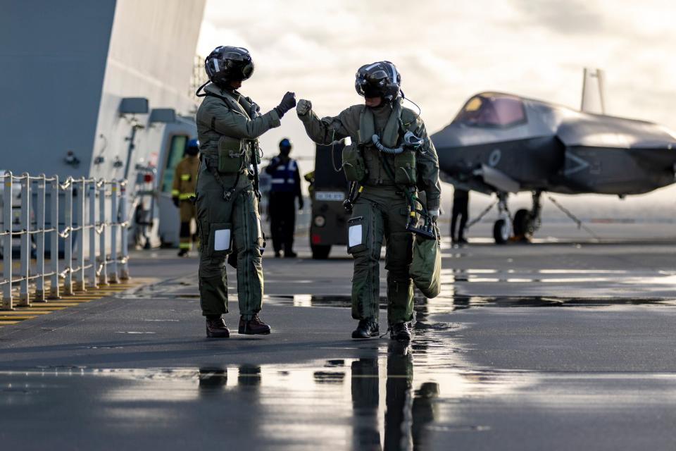 F-35B pilots fist bump on the flight deck of HMS <em>Queen Elizabeth</em>. <em>Crown Copyright</em>