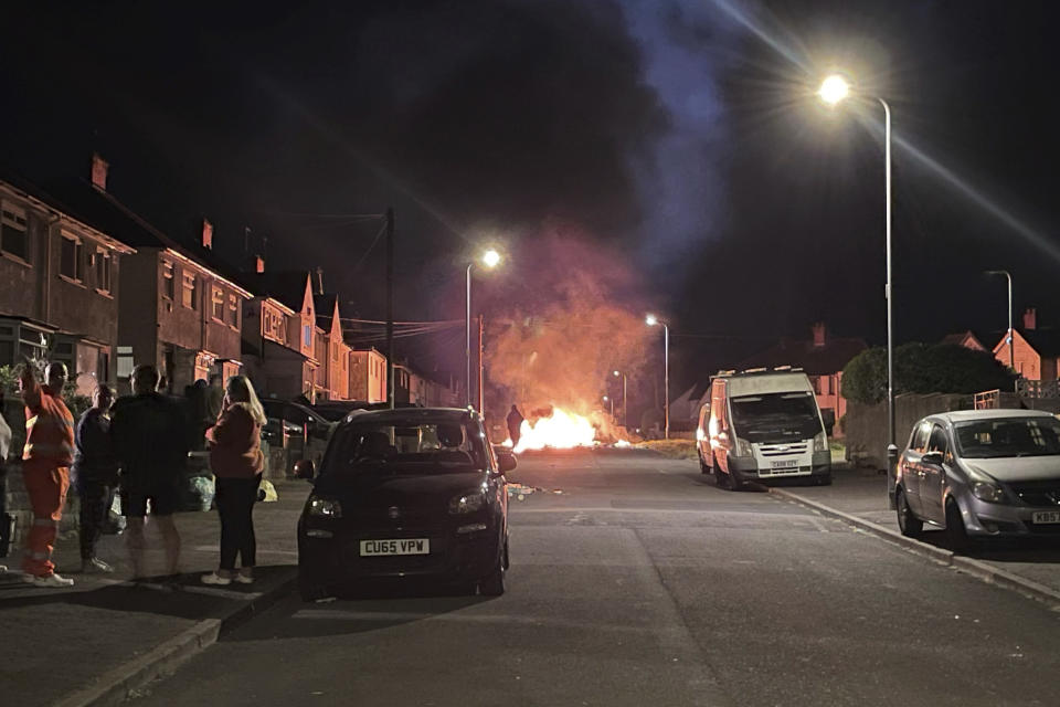 A car burns after being set on fire, on Highmead Road, Ely, in Cardiff, after a crash following a serious road traffic collision on Snowden Road in Ely in Cardiff, Tuesday, May 23, 2023. A few cars were set ablaze and objects were hurled at police after a traffic accident Monday night in the Welsh capital Cardiff grew into what officials described as “large scale disorder.” (Bronwen Weatherby/PA via AP)