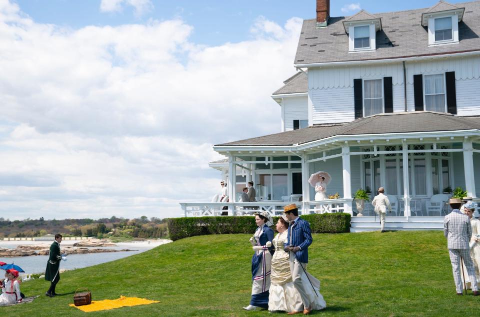 Actors Amy Forsyth (as Caroline “Carrie” Astor), left, Ashlie Atkinson (Mamie Fish) and Harry Richardson (Larry Russell) stroll across the lawn of The Ledges in Newport in the HBO drama "The Gilded Age."