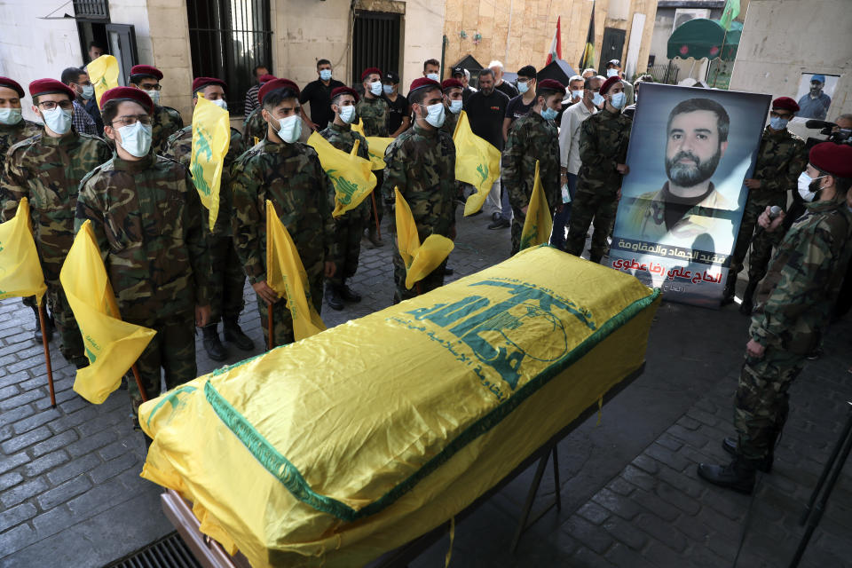 Hezbollah fighters stand in front of the coffin of Ali Atwa, a senior Hezbollah operative, during his funeral procession in the southern Beirut suburb of Dahiyeh, Lebanon, Saturday, Oct. 9, 2021. Atwa was placed on the FBI's most wanted list in 2001, with two other alleged participants in the 1985 hijacking of TWA Flight 847, one of the worst hijackings in aviation history and that lasted for 16 days. (AP Photo/Bilal Hussein)