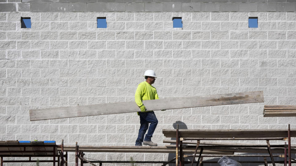 A construction crew member walks on scaffolding at a building site, Wednesday, Sept. 4, 2024, in Waukee, Iowa. (AP Photo/Charlie Neibergall)