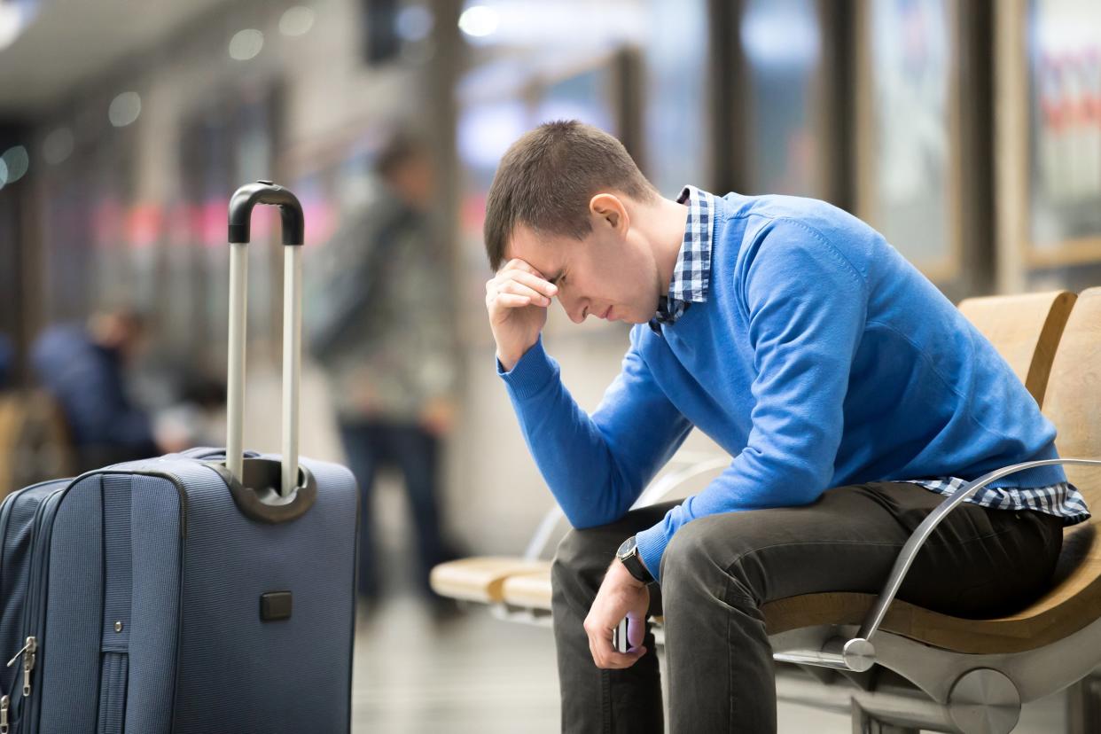 Upset man at the airport with his head down