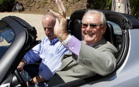 Denmark's Prince Henrik, right, waves as he drives a Tesla Roadster at the electric car maker's headquarters in Palo Alto - Credit: AP