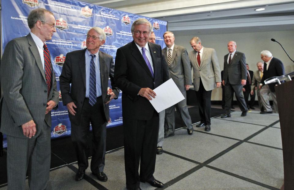 Virginia Tech President Charles Steger, third from left, smiles as he and others arrive for a media availability after a BCS presidential oversight committee meeting, Tuesday, June 26, 2012, in Washington. A committee of university presidents on Tuesday approved the BCS commissioners' plan for a four-team playoff to start in the 2014 season. (AP Photo/Alex Brandon)