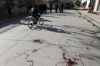 Blood stains the ground at the scene where gunmen fired in Kabul, Afghanistan, Sunday, Jan. 17, 2021. Gunmen fired on a car in northern Kabul on Sunday, killing two women judges who worked for Afghanistan's high court and wounding the driver, a court official said. It was the latest attack in the Afghan capital during peace talks between Taliban and Afghan government officials in Qatar. (AP Photo/Rahmat Gul)