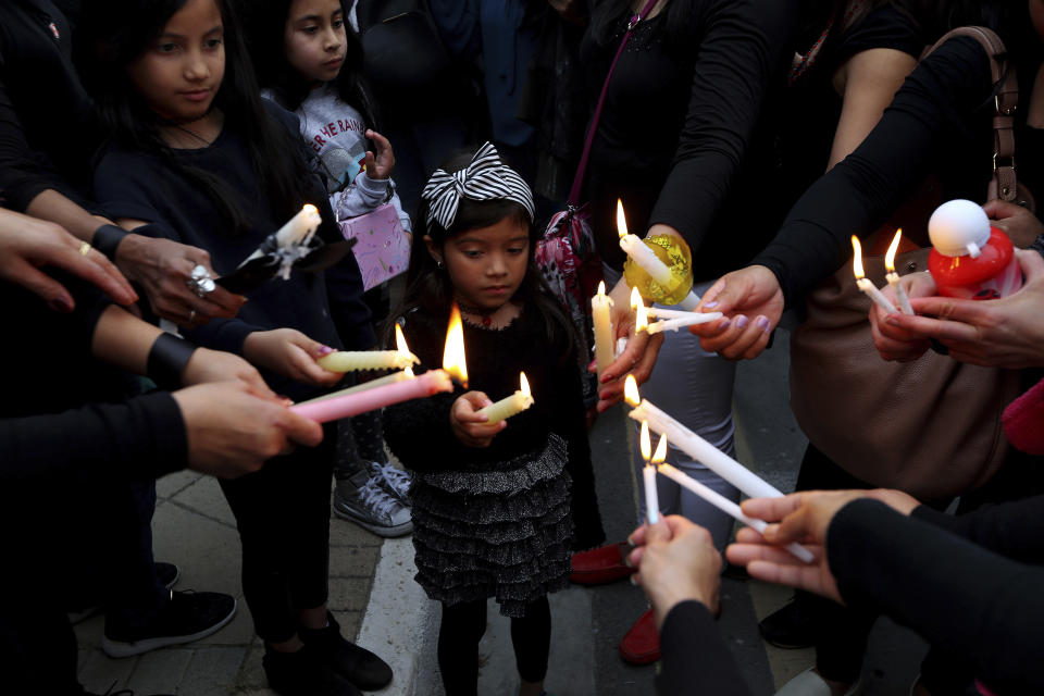 A girl among people during a vigil, outside of the presidential palace in Nicosia, Cyprus, Friday, April 26, 2019. Up to 1,000 people turned out in front of Cyprus' presidential palace to remember the five foreign women and 2 girls that a military officer has confessed to killing in what police are again calling "an unprecedented crime." (AP Photo/Petros Karadjias)