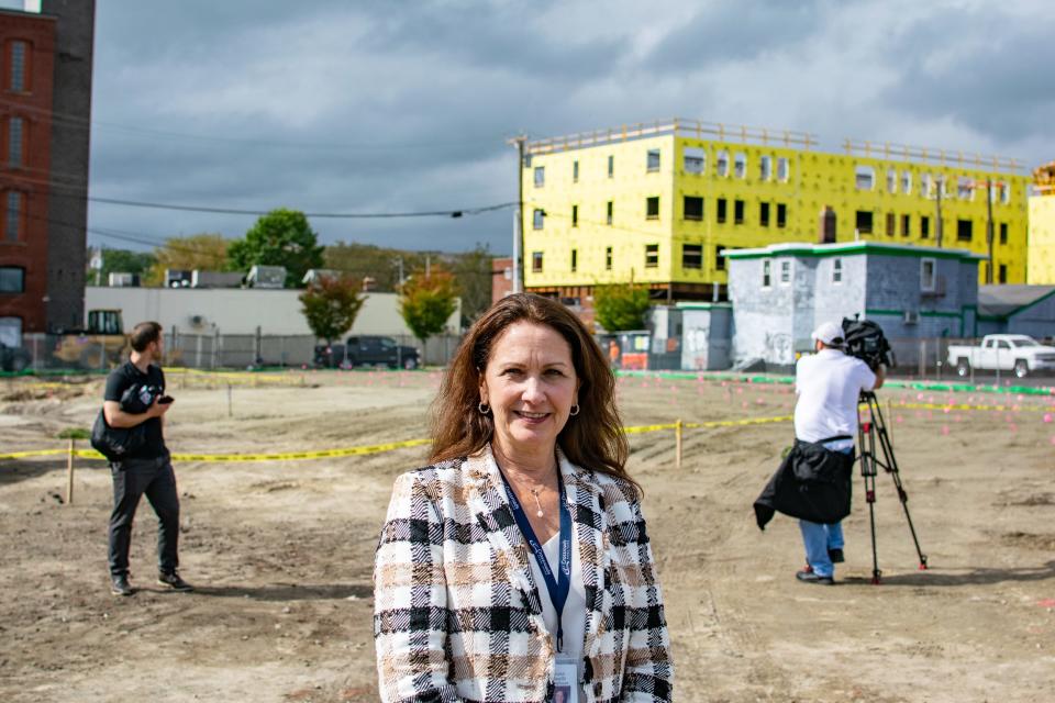 Crossroads Rhode Island CEO Karen Santilli stands on a former parking lot to be developed into a 176-unit apartment building. She is trying to raise $15 million to plug financing holes in three housing projects under or nearing construction.