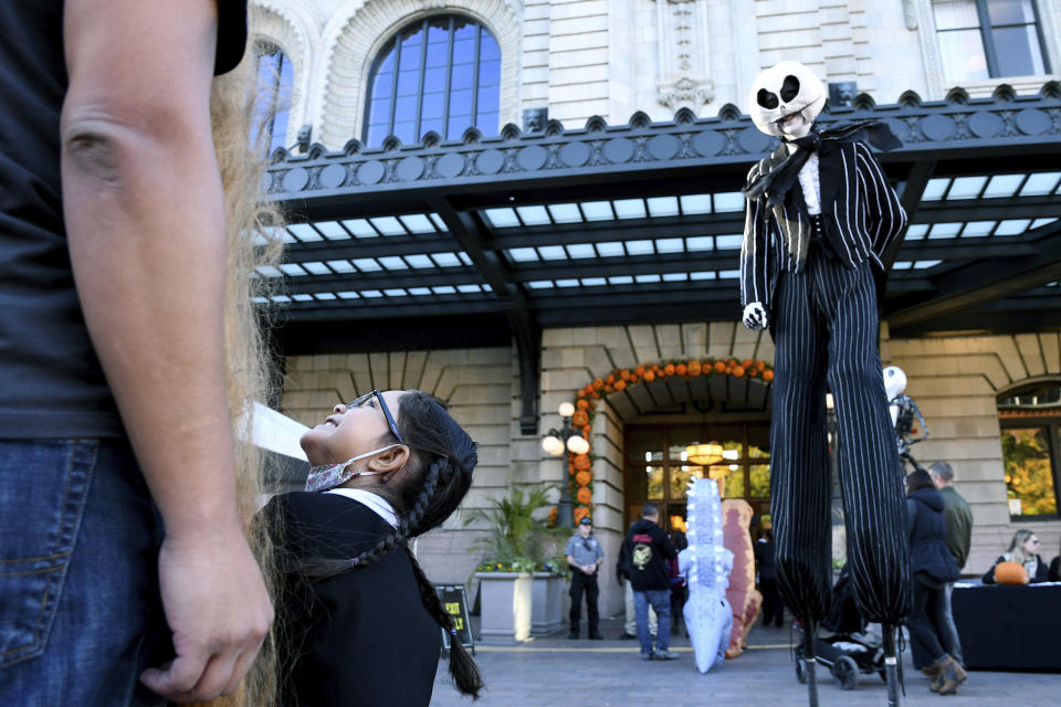 Colette Thompson, 4, laughs at a performer during a Halloween celebration at Denver's Union Station on Thursday, Oct. 28, 2021. Though the pandemic remains a concern, top health officials are largely giving outside activities like trick-or-treating the thumbs up. (AP Photo/Thomas Peipert)