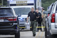 A Morgan County, Ala. investigator works at the scene, Friday, June 5, 2020, in Valhermoso Springs, Ala., where numerous people were found fatally shot. Deputies responding to a call about a shooting in Alabama found seven people dead inside a home that had been set afire early Friday, authorities said. (Jeronimo Nisa/The Decatur Daily via AP)