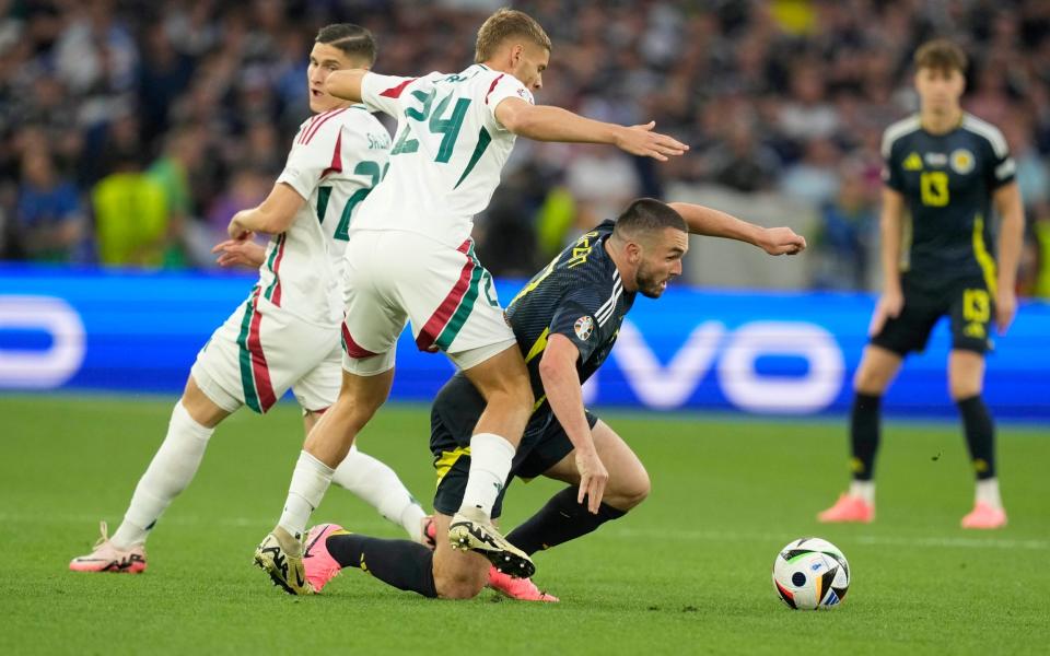 Scotland's John McGinn, right, is challenged by Hungary's Marton Dardai, left, and Hungary's Roland Sallai